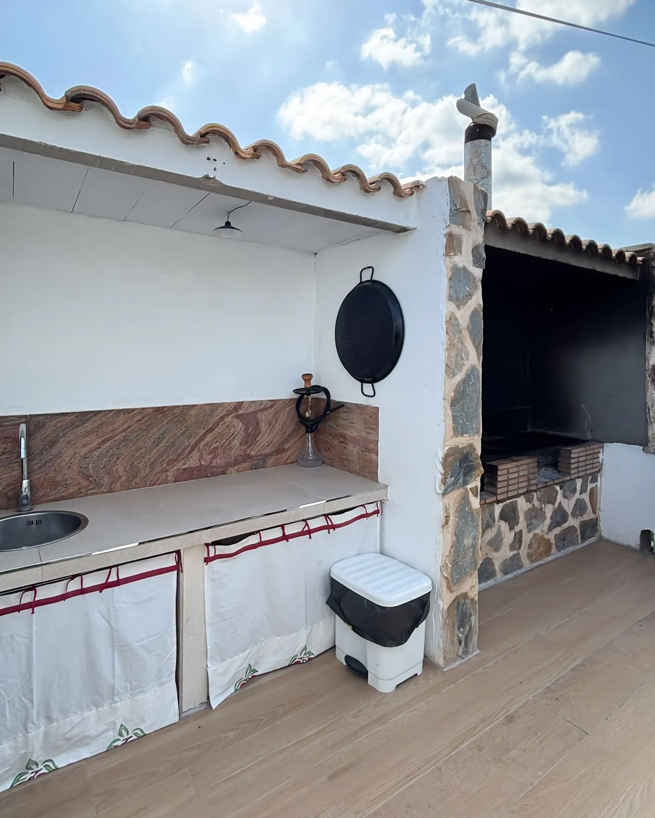 Zona de cocina exterior con fregadero y encimera junto a la barbacoa