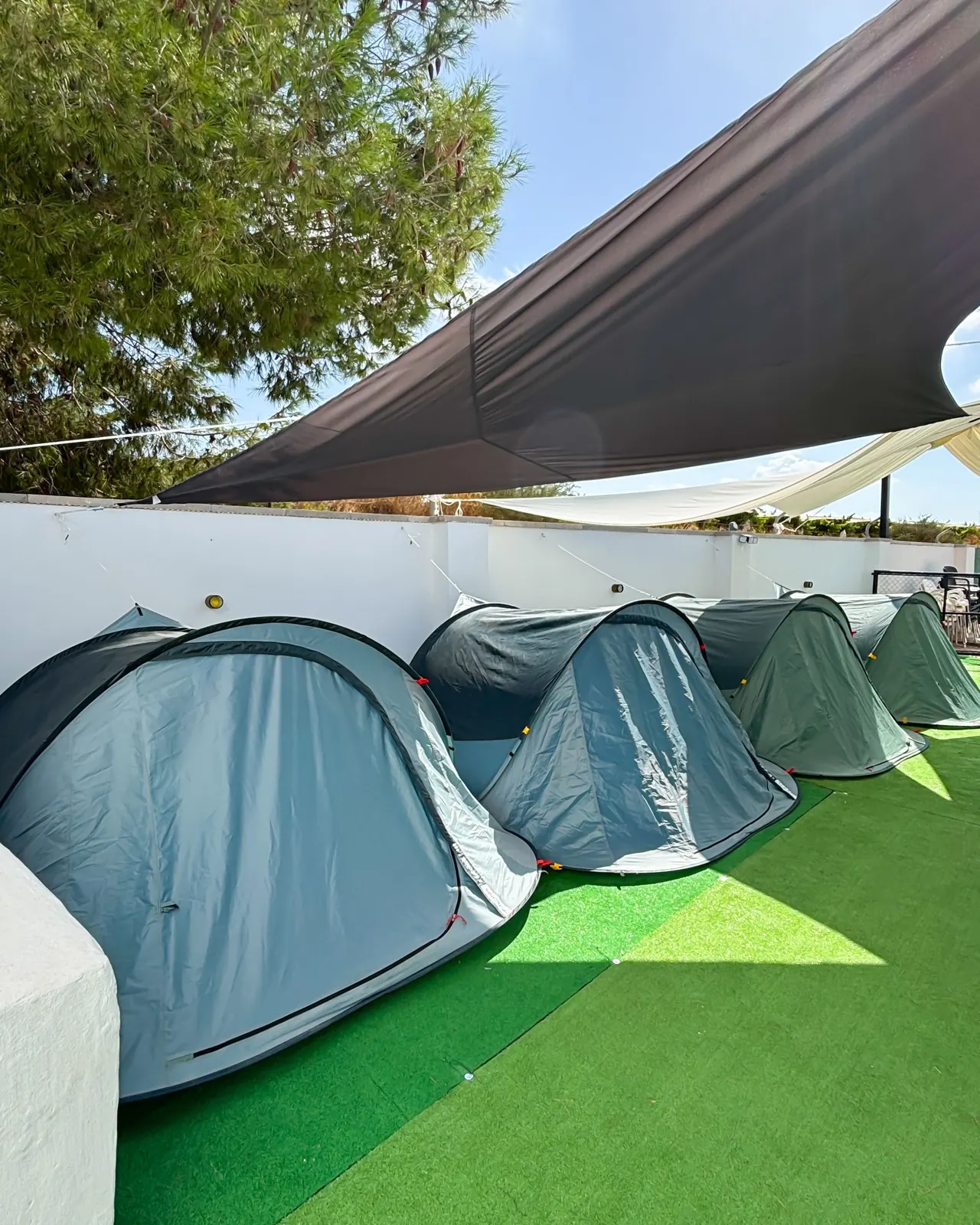 Fila de tiendas de campaña sobre césped artificial