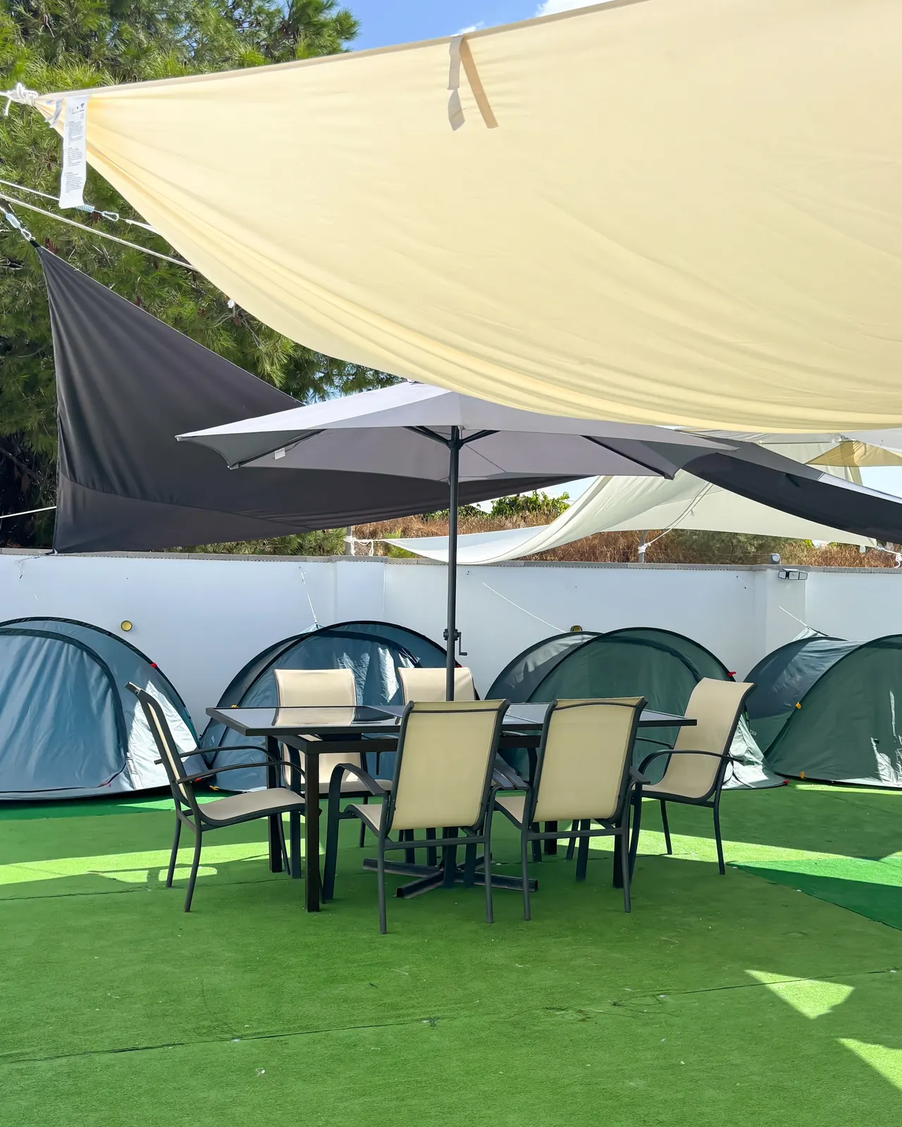 Mesa de comedor exterior junto a la zona de tiendas de campaña
